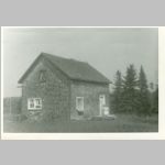 House of Philip & Daisy GOATCHER in Farmborough, , QC, Canada. c1946<br>Note the double windows in the kitchen & the upstairs window is divided.  Note the ladder on the roof. Daisy nee SULLIVAN GOATCHER is sitting by the front door. Note the flower box in the master bedroom window. <br>Source: images/5DApr15/0005DApr15/ (73.72 KB)