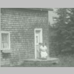 Daisy GOATCHER at home. c1946<br>Daisy is sitting by the front door of her homestead at Farmborough.  Location is a few miles south of the airport serving Rouen/Noranda, , QC, Canada in 1995. <br>Source: images/5DApr14/0005DApr14/ (61.88 KB)